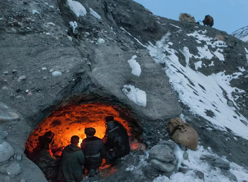 a group of people standing inside of a cave summer