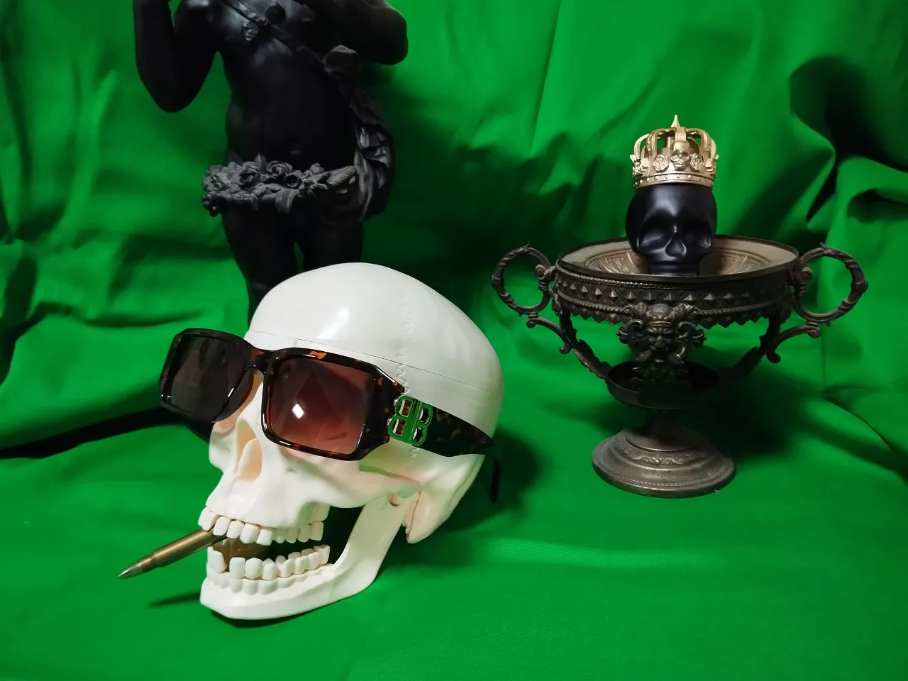 a fake skull wearing sunglasses next to a fake skull wearing a crown