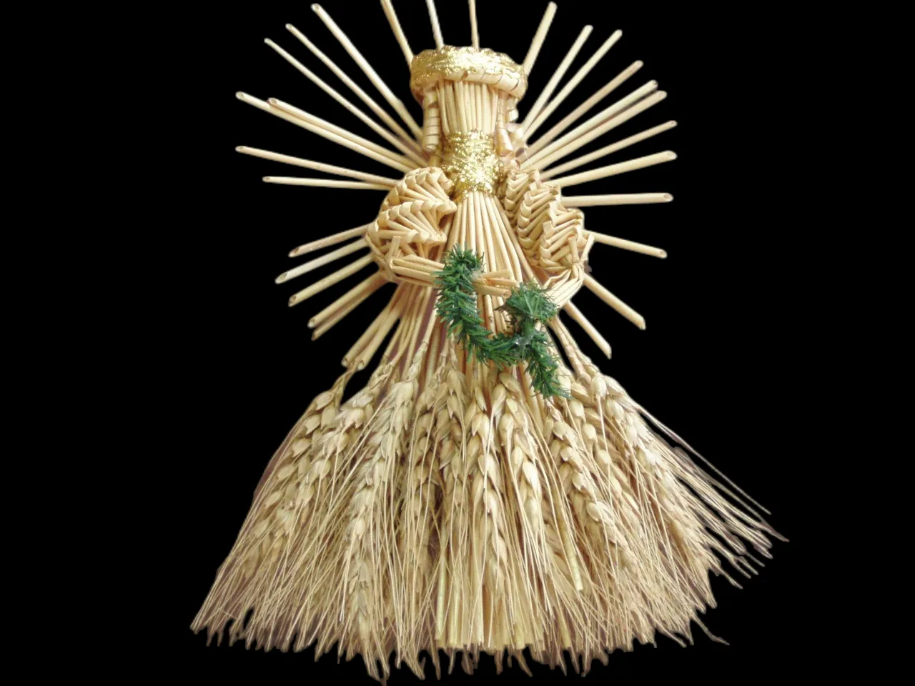 a statue made out of straw with a wreath on top of it