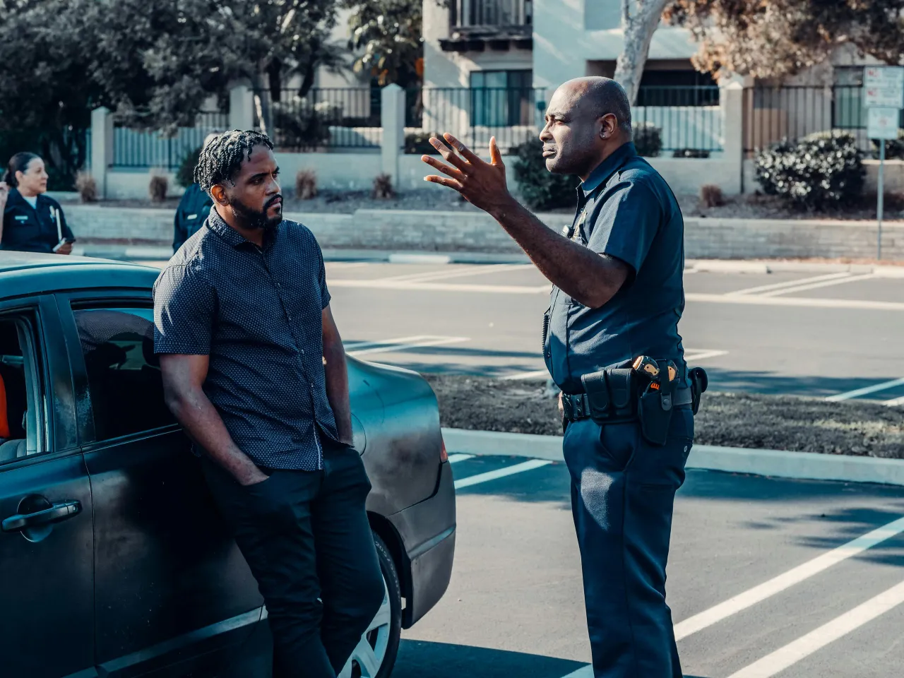 2 men standing next to a car accident, night time