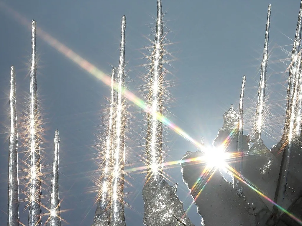 the sun shines brightly on a snow covered mountain