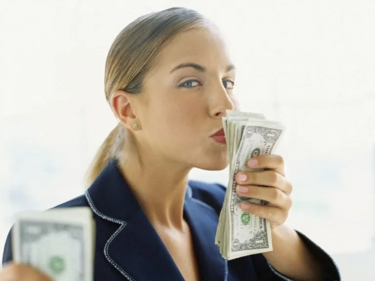 a woman in a business suit holding a stack of money