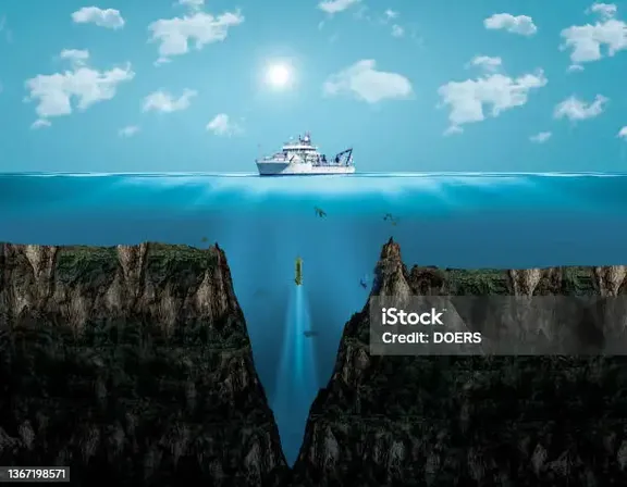 a boat floating in the ocean near a cliff