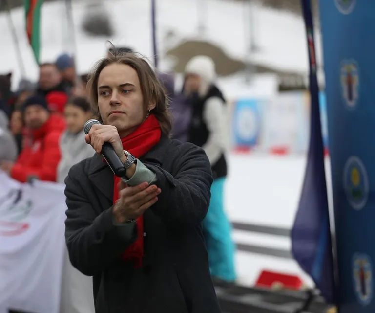 a man holding a microphone in front of a crowd