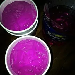 two styrofoam cups of purple liquid sitting on a table