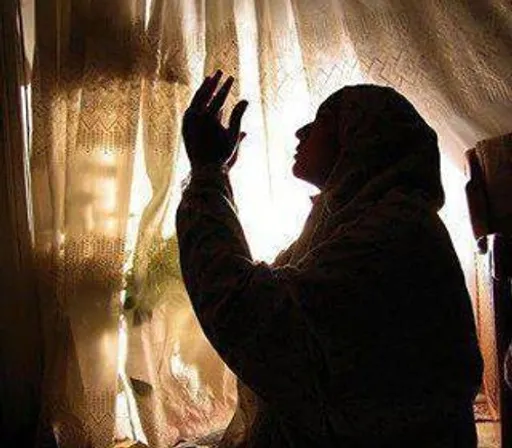 a woman standing in front of a window next to a curtain