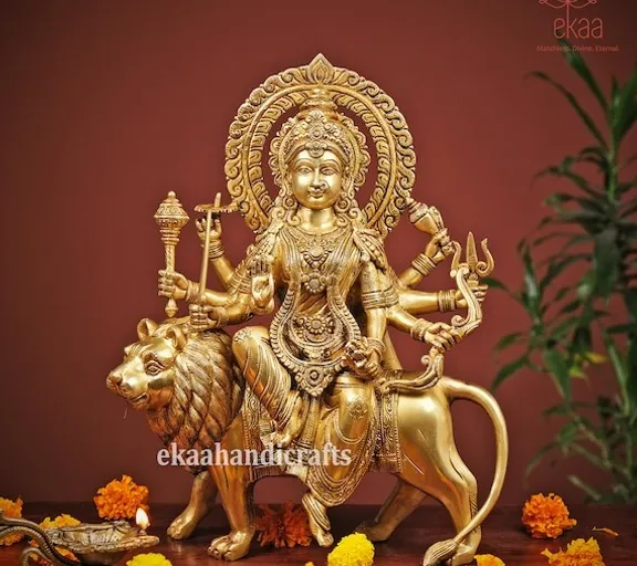 a golden statue of a woman sitting on top of a lion