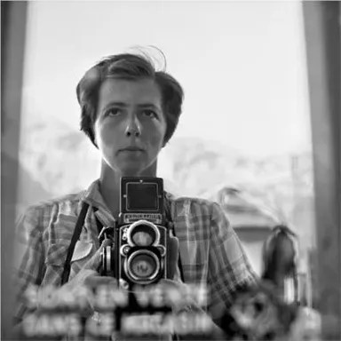 a woman holding a camera in front of a mirror