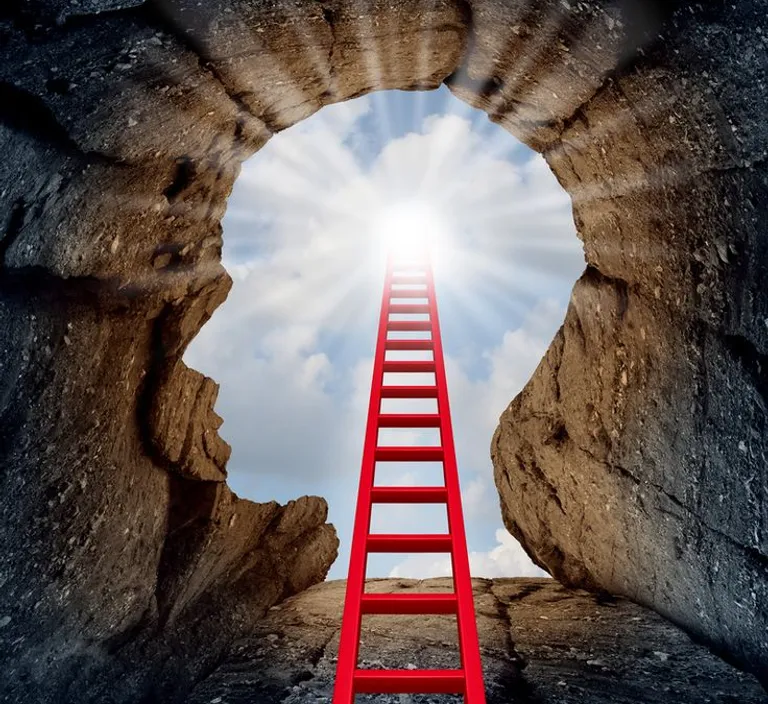 a red ladder going up into a cave