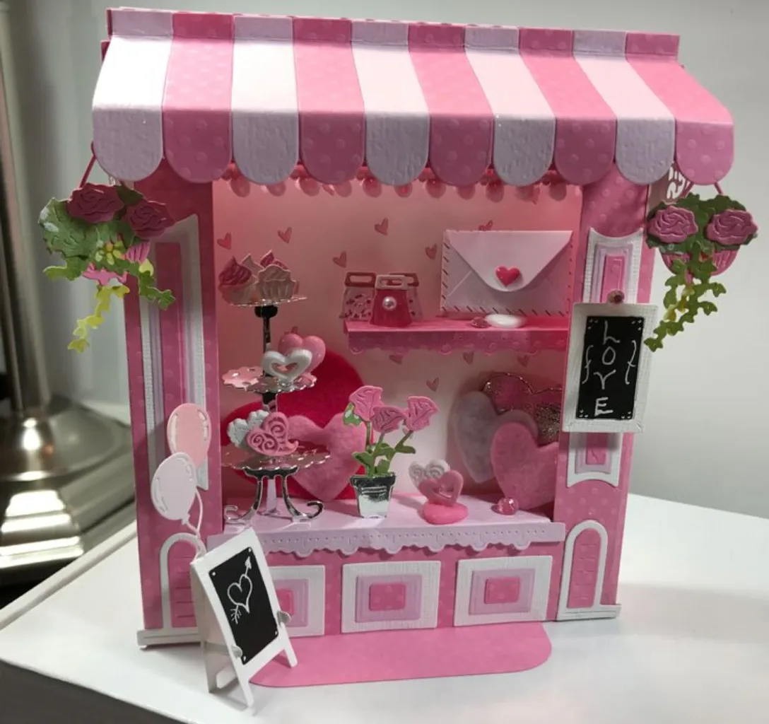 a pink and white doll house with a pink and white awning and barbie