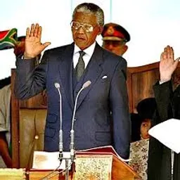 when nelson mandela was sworn in in 1994, 3d, in a suit and tie standing in front of a microphone