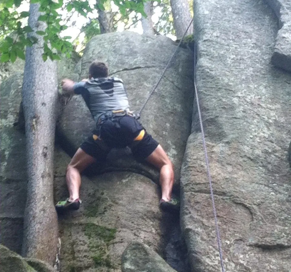 a man climbing up the side of a large rock