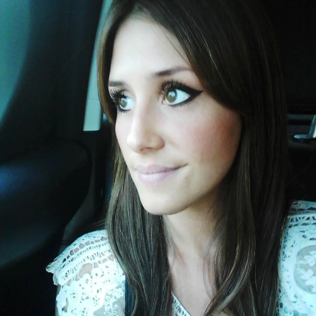 a woman with blue eyes sitting in a car