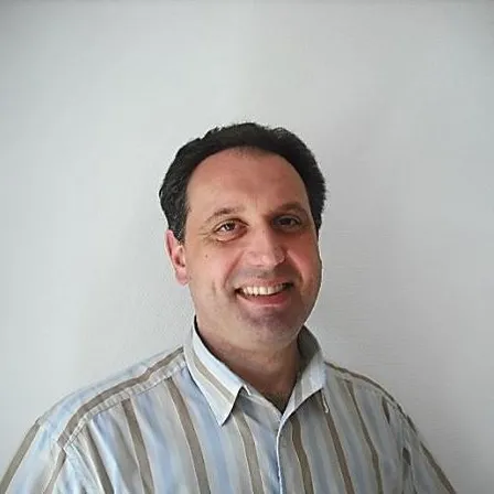 a man in a striped shirt smiling at the camera