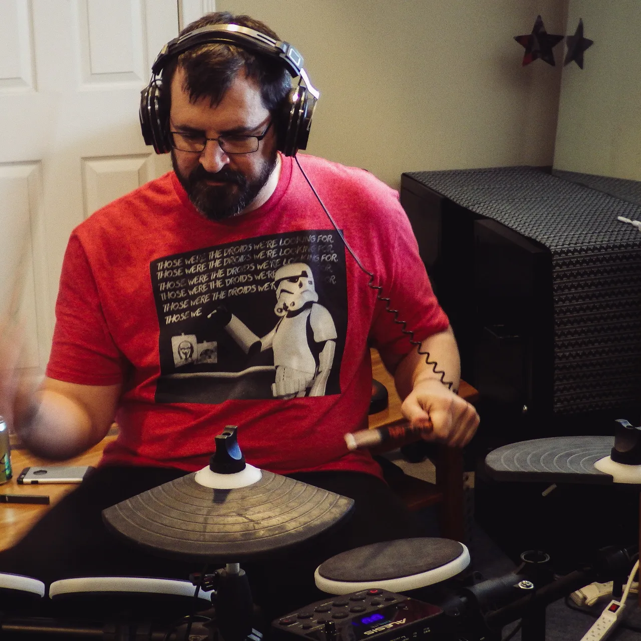 a man playing an electronic drumset with headphones on