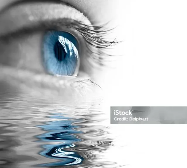 a close up of a blue eye reflecting in water