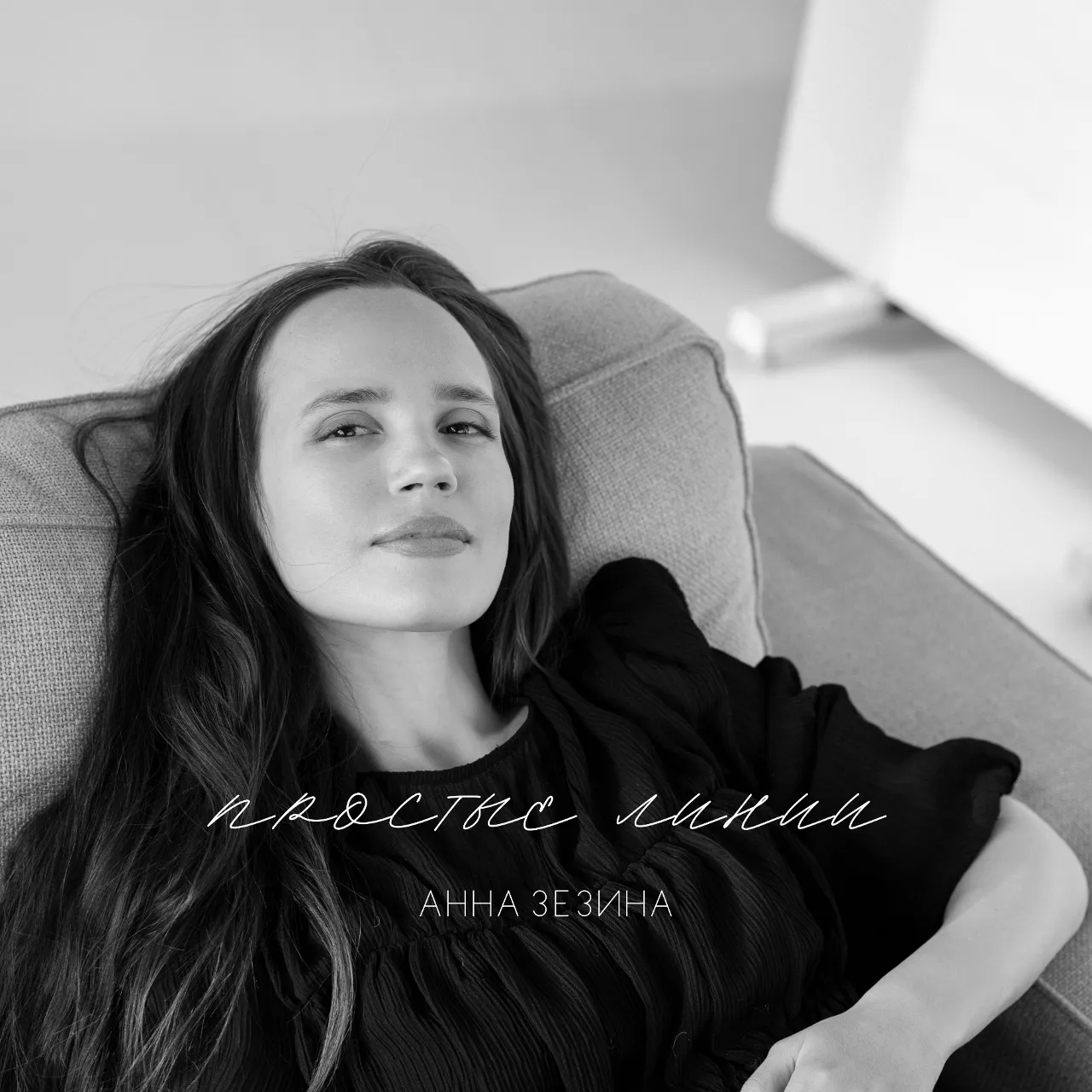 a black and white photo of a woman sitting on a couch