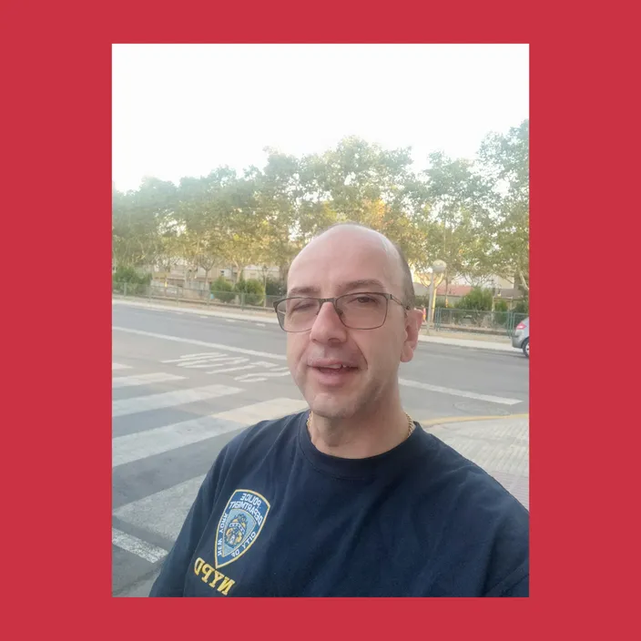 a man with glasses and a police shirt