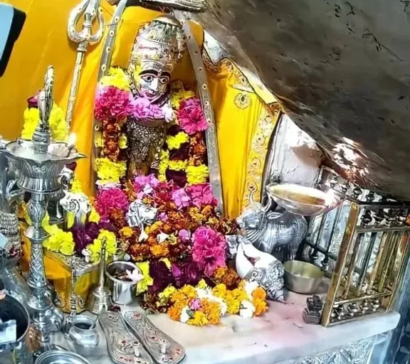 a shrine with a statue of a person surrounded by flowers