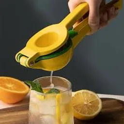 a person squeezing a lemon into a glass of water