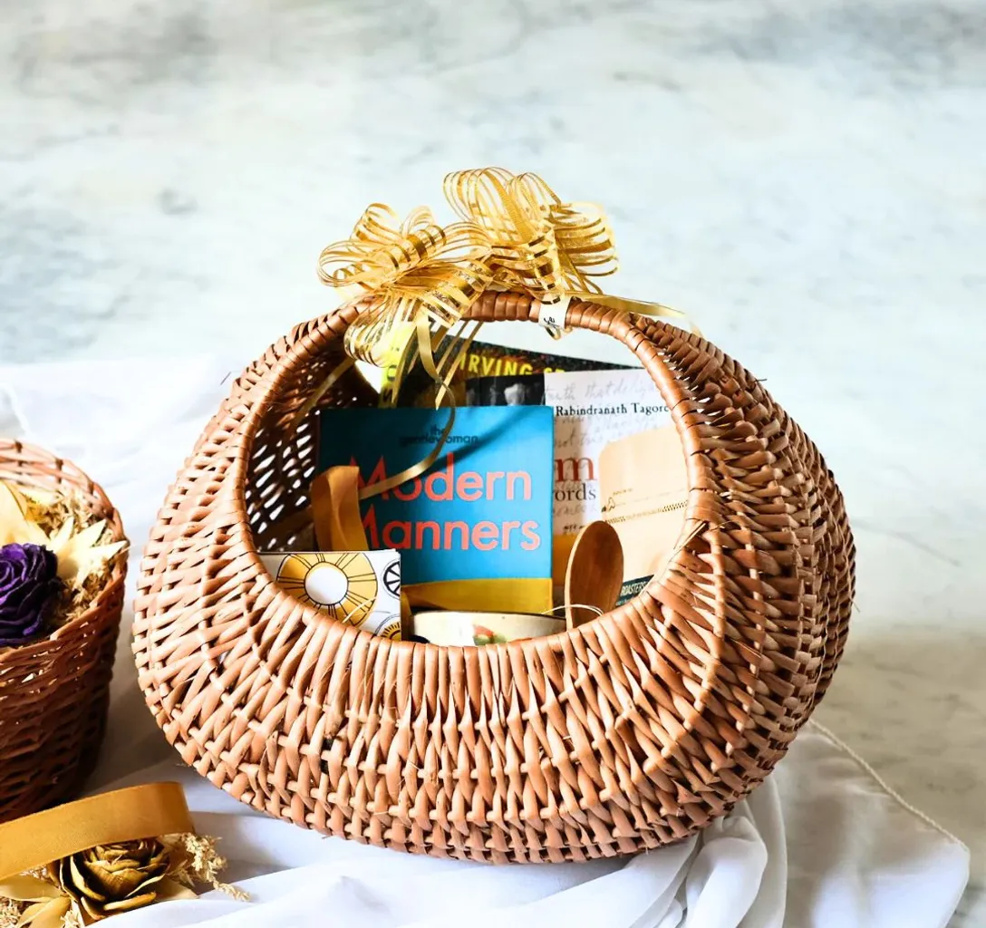 a wicker basket covered with cloth, under a big tree