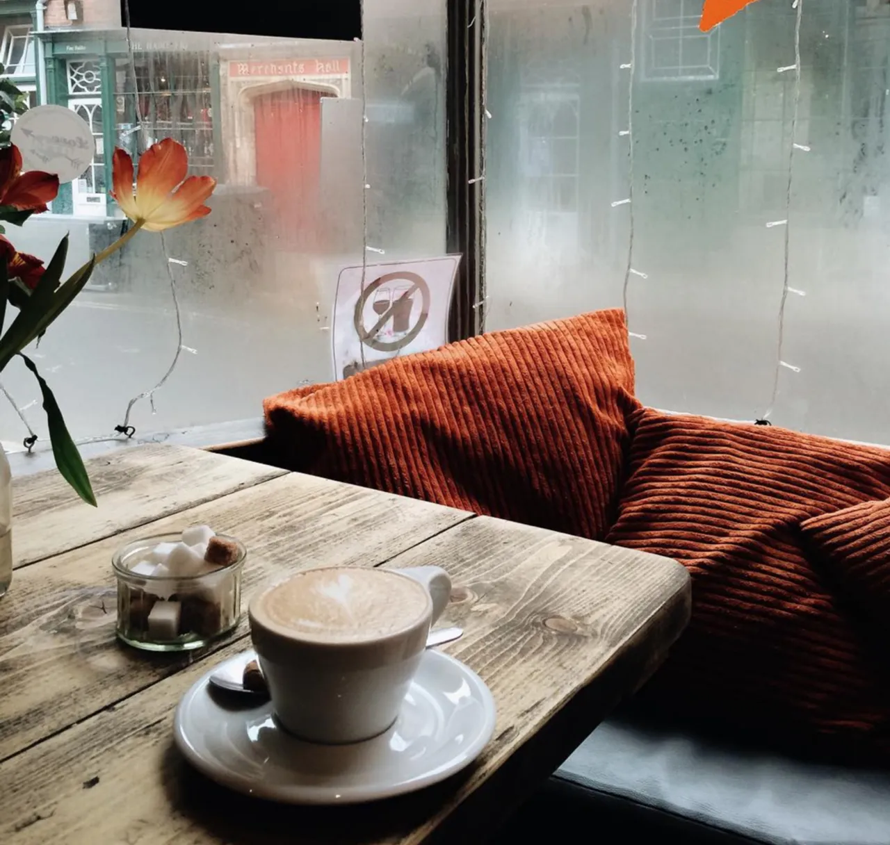 a cup of coffee sitting on top of a wooden table