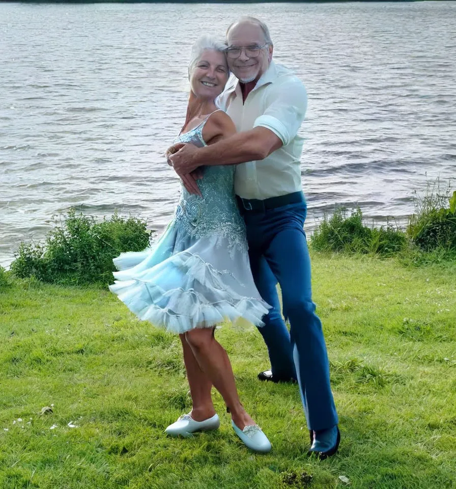 a man and a woman dancing in front of a body of water