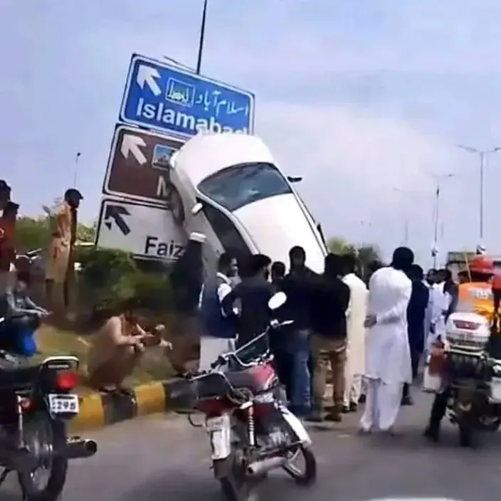 a group of people standing on the side of a road