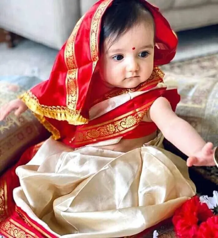 a baby dressed in a red and gold costume