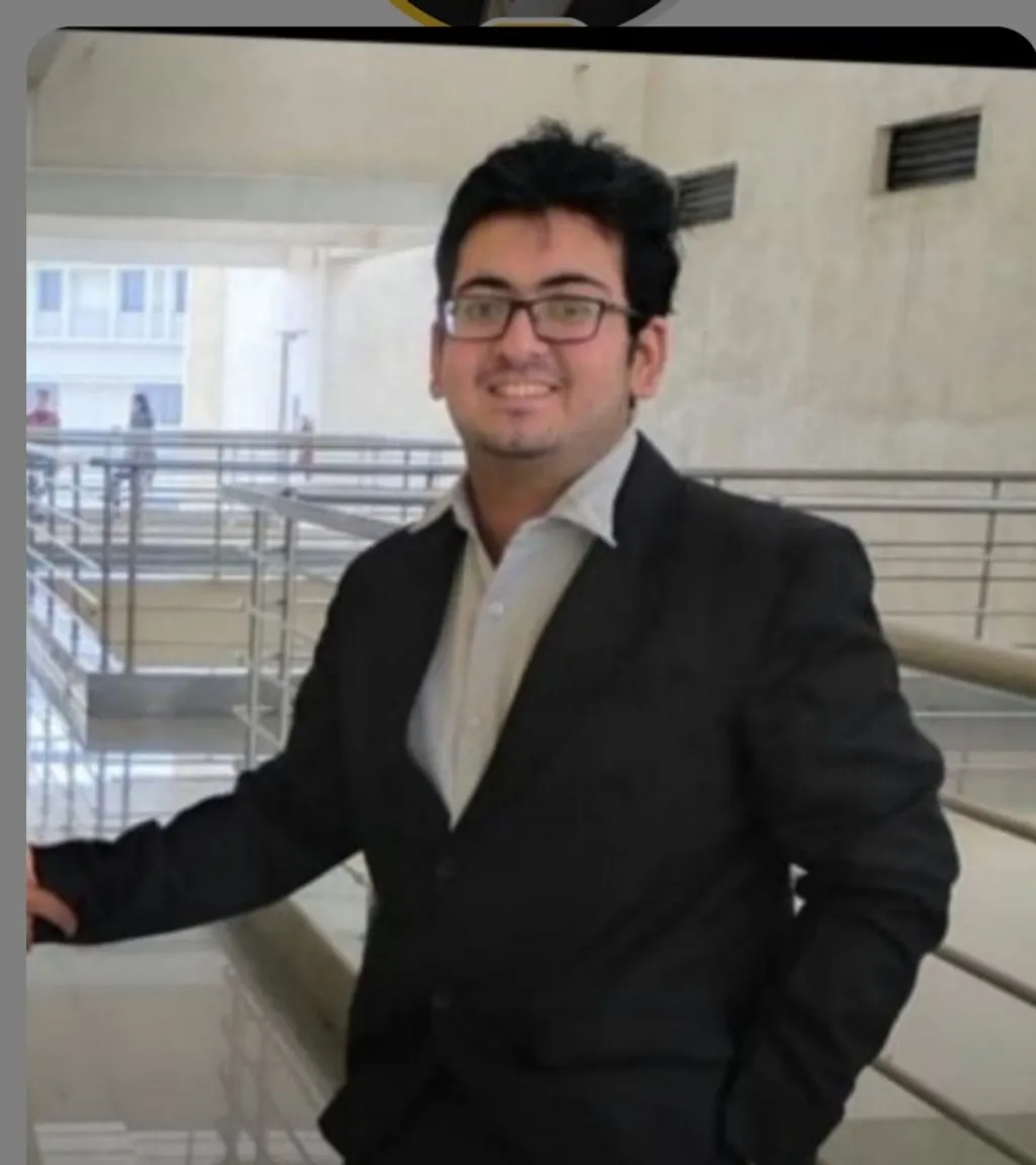 a man in a suit and glasses standing in front of stairs