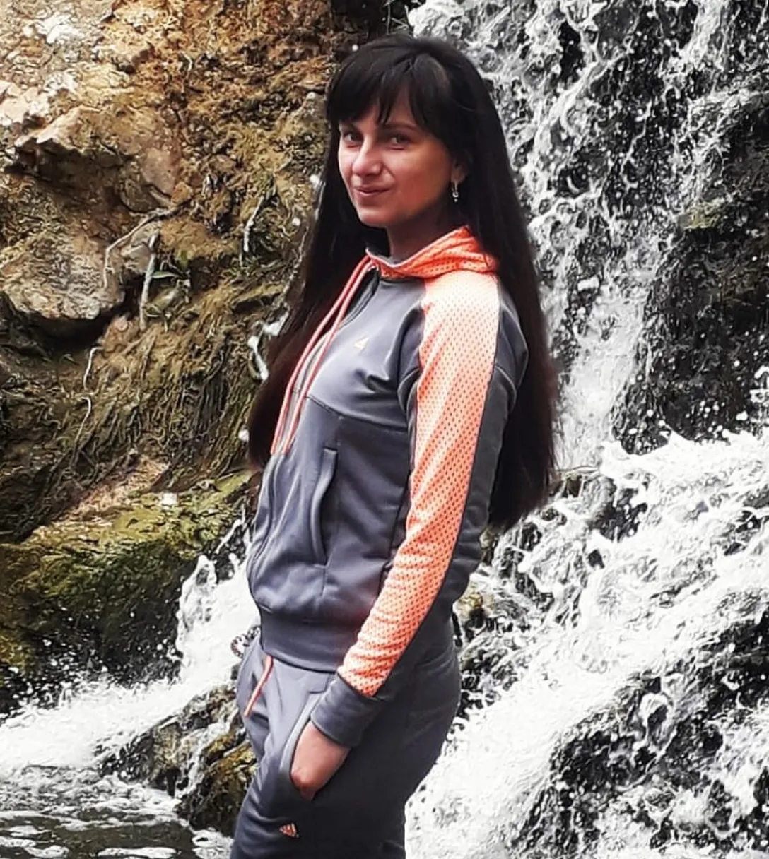 a woman standing in front of a waterfall