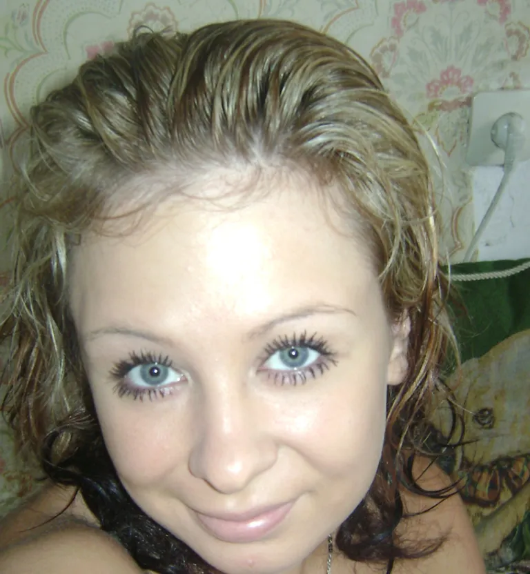 a woman with blue eyes is smiling for the camera