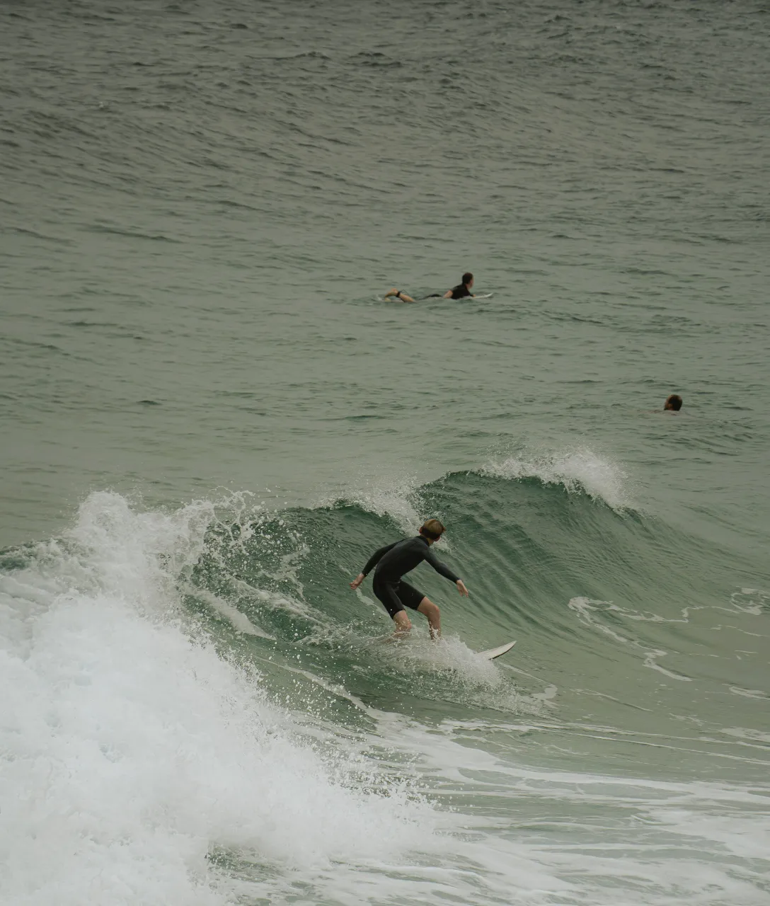 a man riding a wave on top of a surfboard