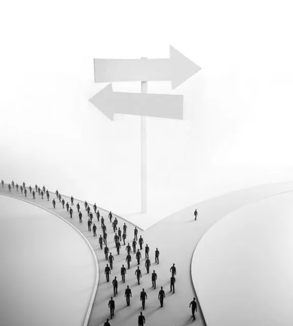 a group of people walking up a hill towards a sign