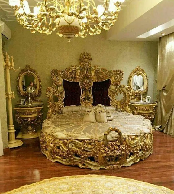 a fancy bed in a fancy bedroom with a chandelier