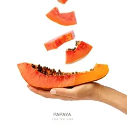 a hand holding a piece of papaya sliced in half