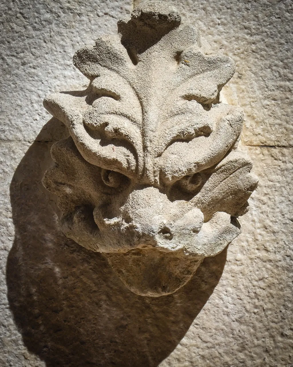 a close up of a stone face on a wall