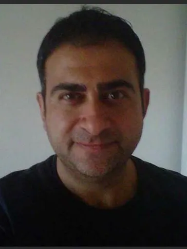 a man in a black shirt looking at the camera