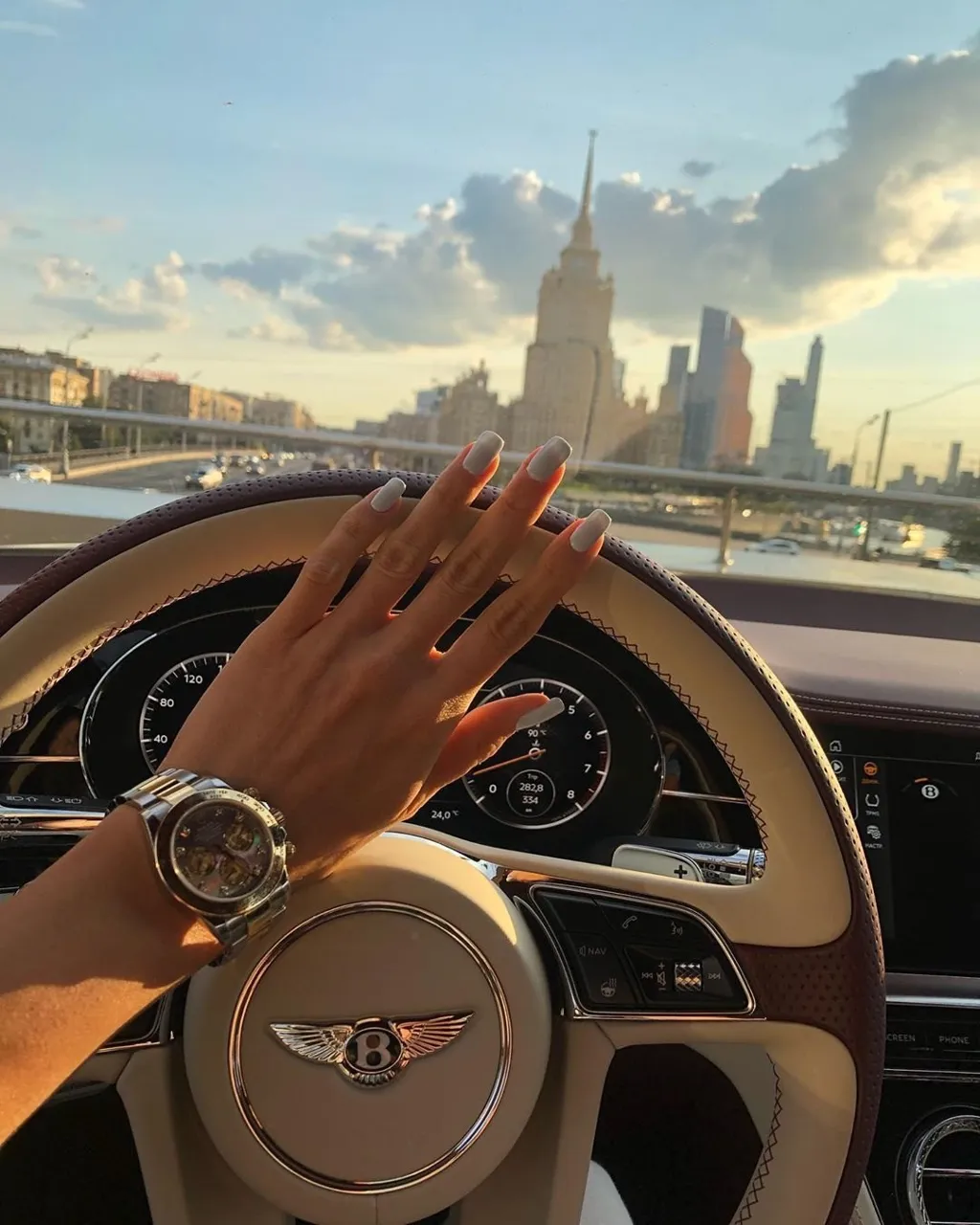 a person's hand on the steering wheel of a car