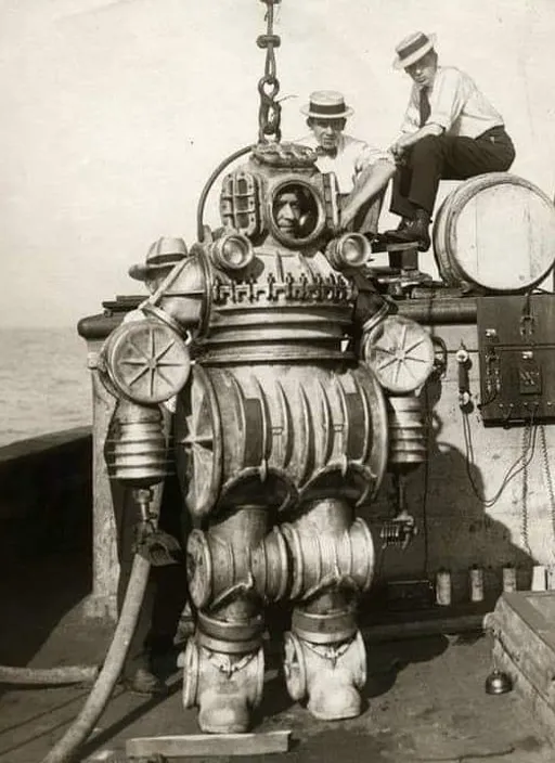 a black and white photo of a man sitting on top of a machine