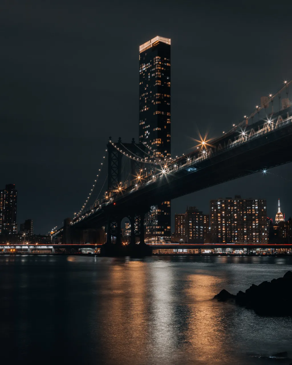 a night scene of a bridge and a city