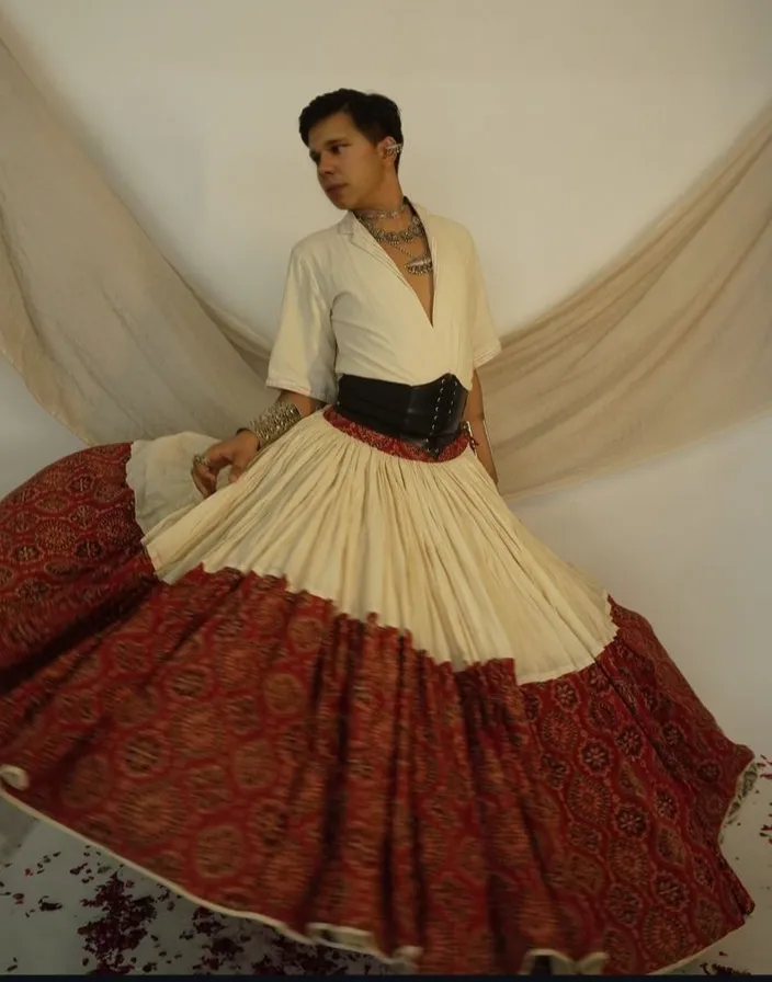 a man in a long skirt is posing for a picture