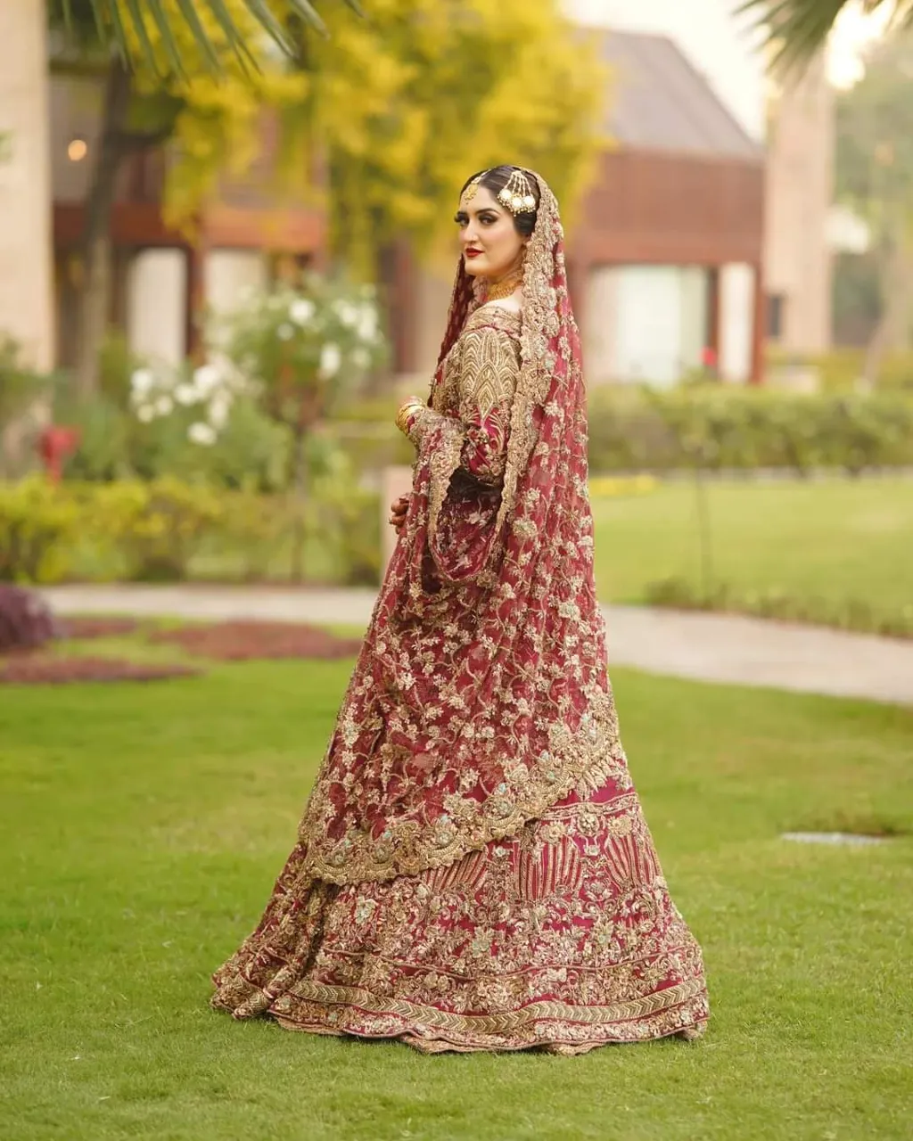 Bridal gown with flowing red and gold fabric in warm golden hour lighting