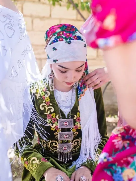 a woman in a colorful dress sitting on the ground