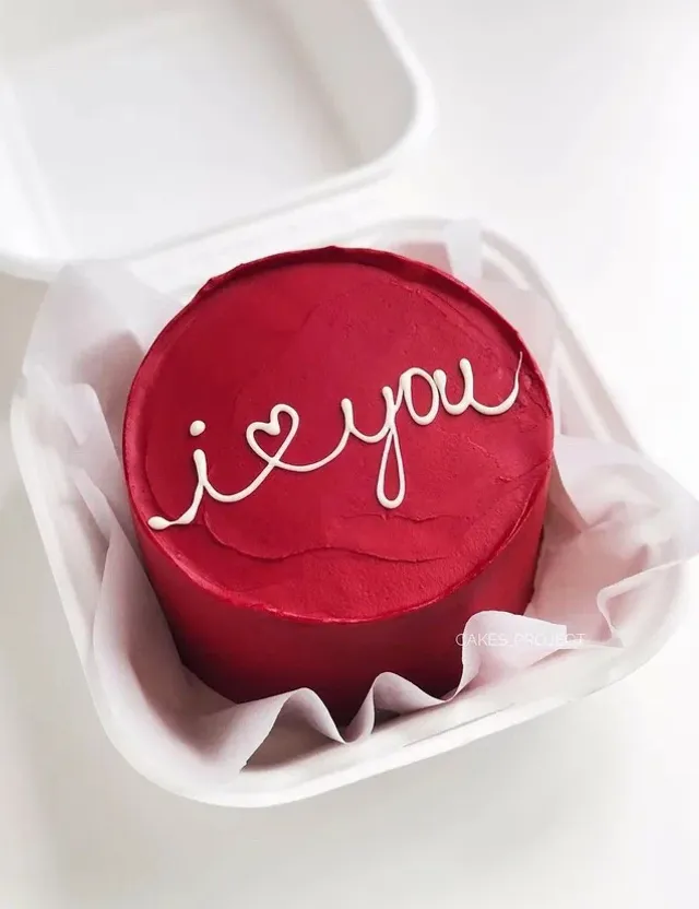 a red cake with the word i love you written on it