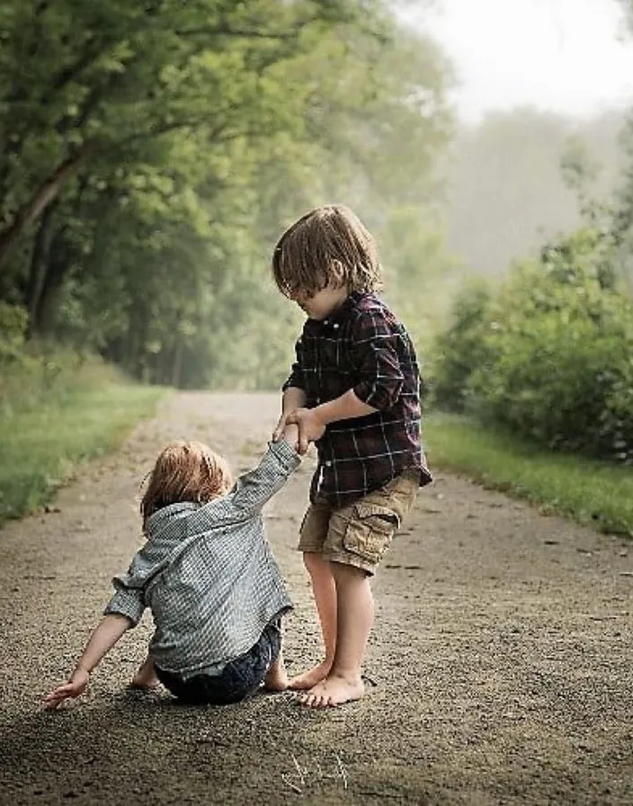 two young boys playing on a dirt road