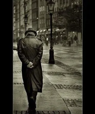 a man walking down a street next to a lamp post