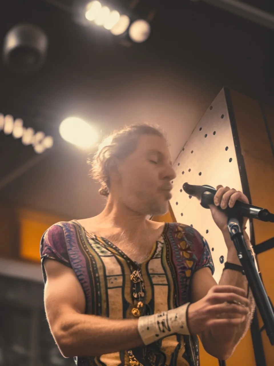 a man holding a microphone while standing in front of a microphone