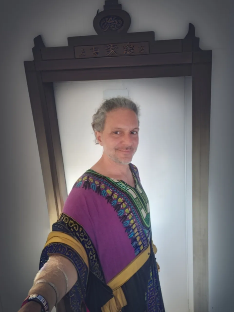 a man in a purple and blue dress standing in front of a mirror