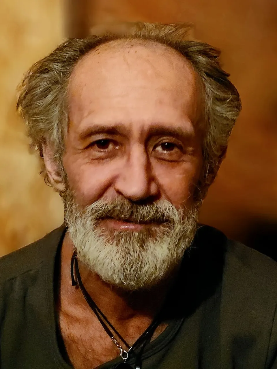 A close-up of a person with a beard, with bokeh lights in the background